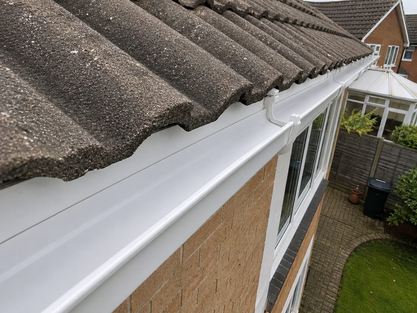 The same gutter fully cleared and flowing freely after cleaning